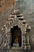 Bagan Myanmar. Htilominlo temple. Niches of the vaulted corridor of the ground floor with stone Buddha images. 